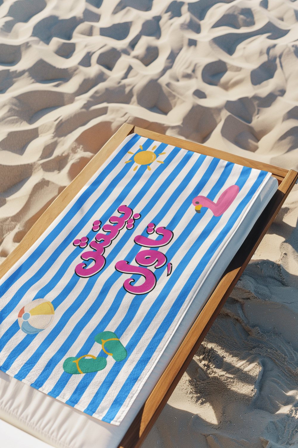 Striped beach towel with 'Beach Towel' arabic text and graphics on sandy background
