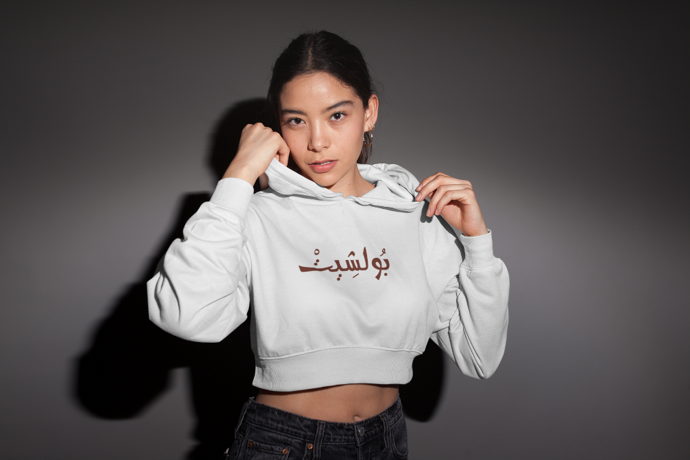 A cool woman wearing a crop top hoodie with Arabic Word. 
