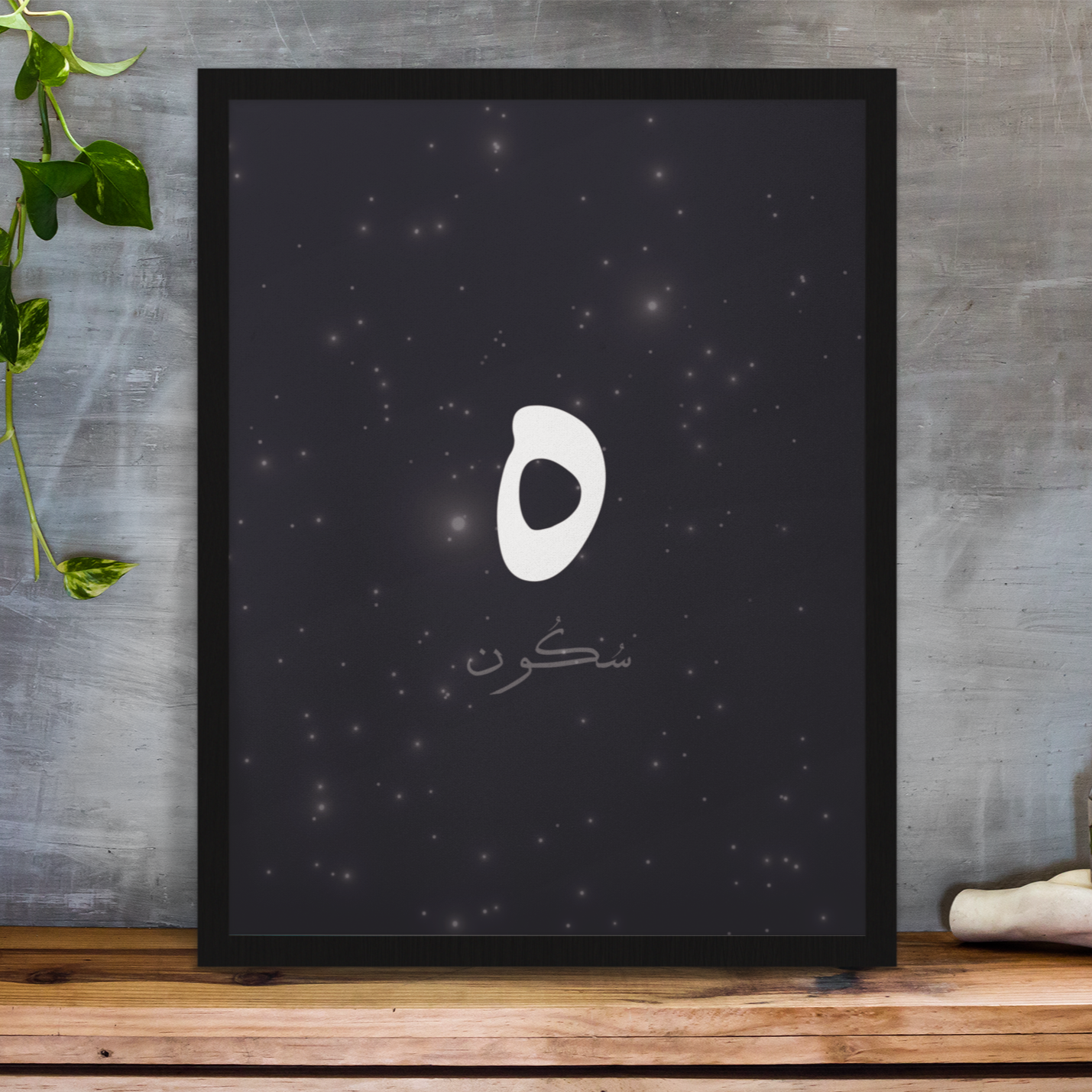 Framed wall art print with Arabic word “سكون” on black starry background