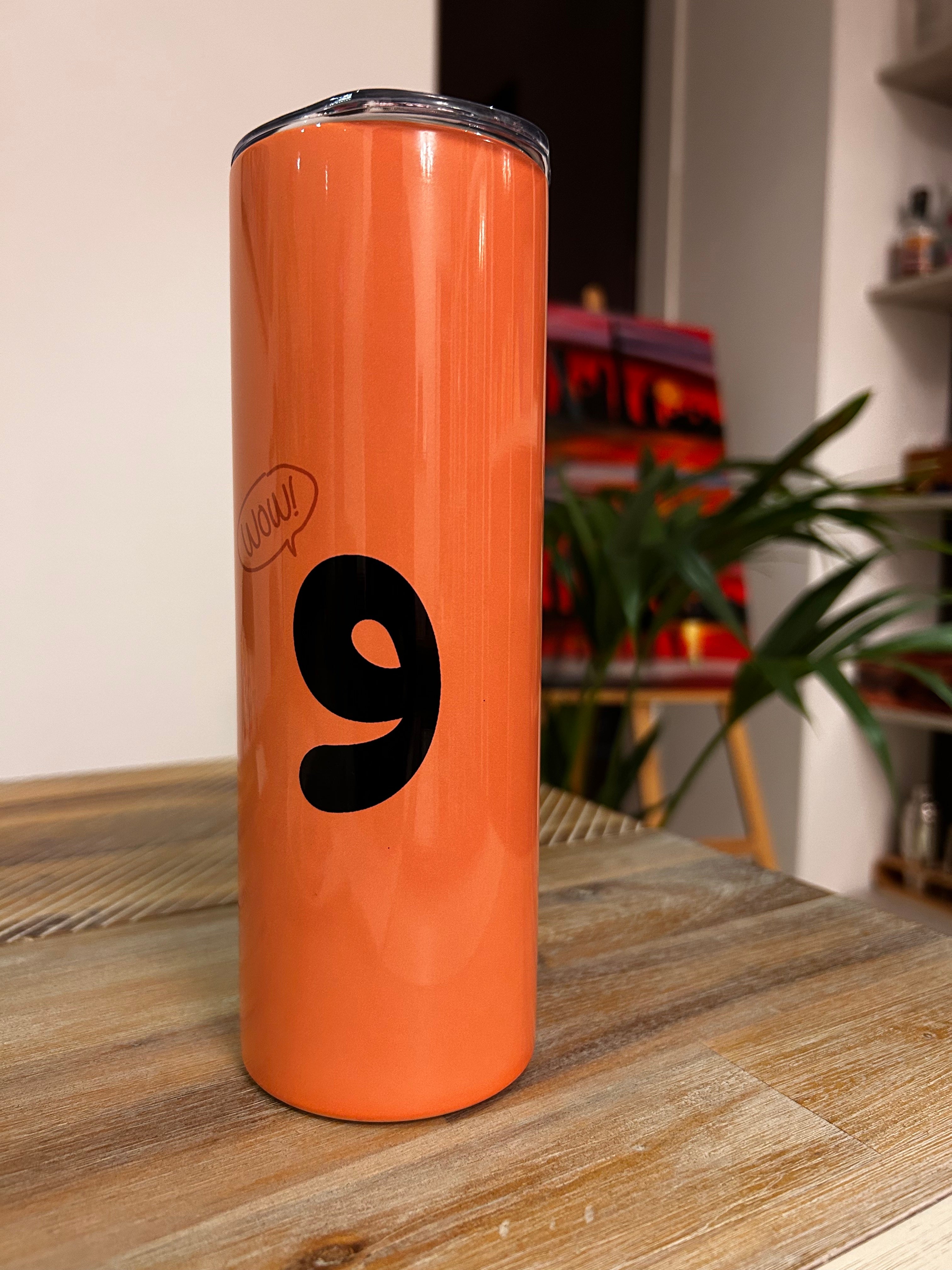 Orange tumbler with bold arabic letter and speech bubble saying wow