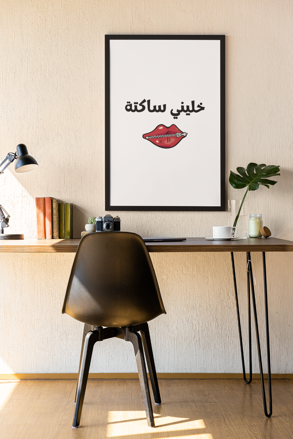Modern office setup with a desk, chair, and framed poster on a wall.
