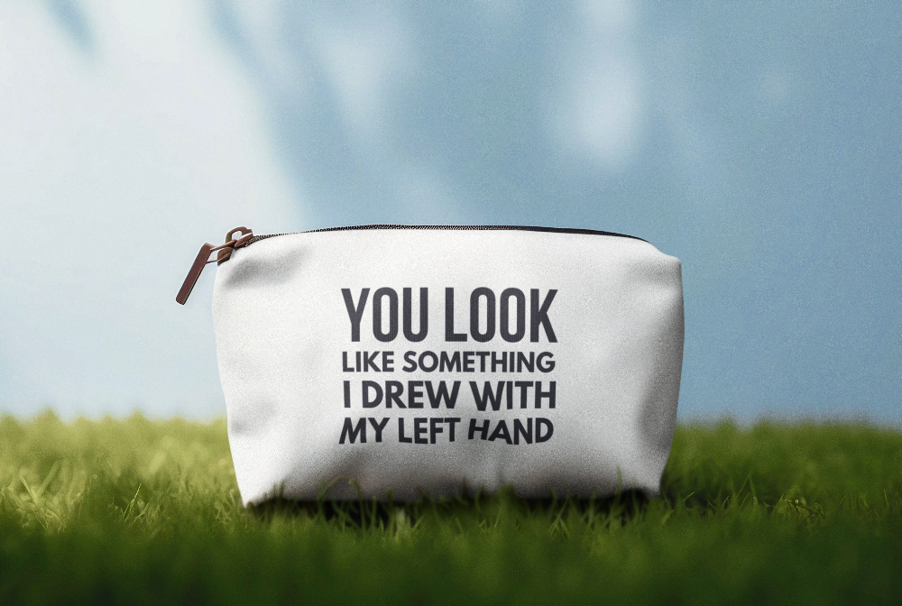 White pouch with text on grass and blue sky