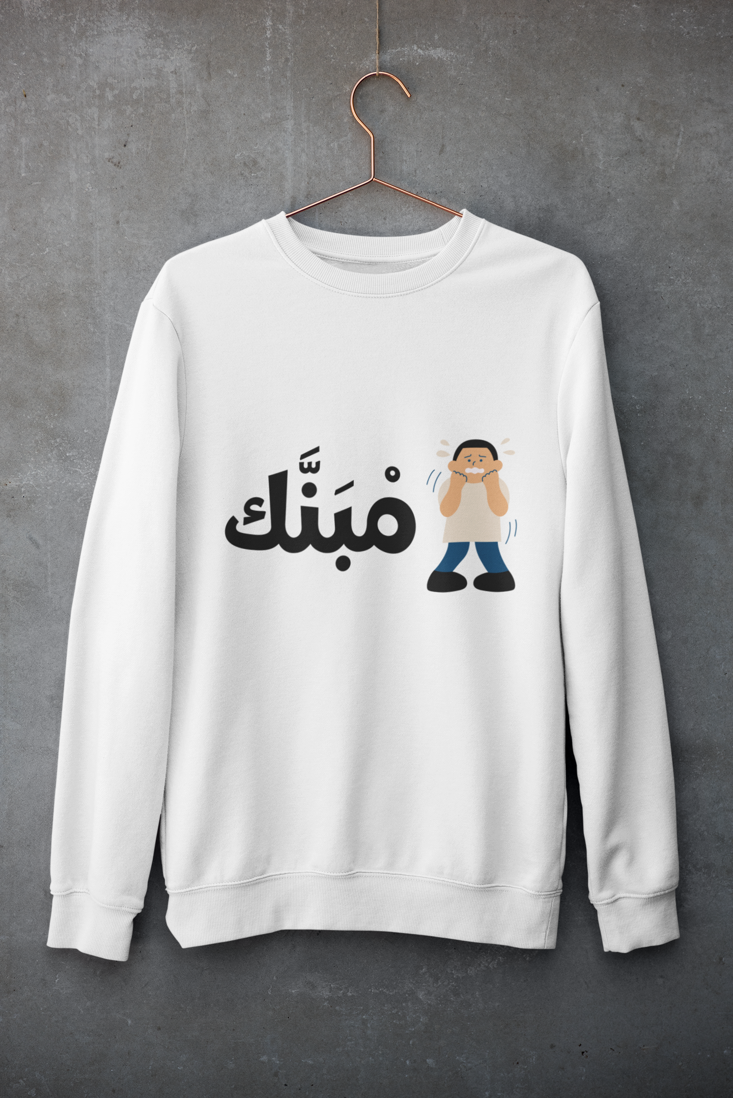 White sweatshirt with Arabic text “مبنك” and cartoon character illustration