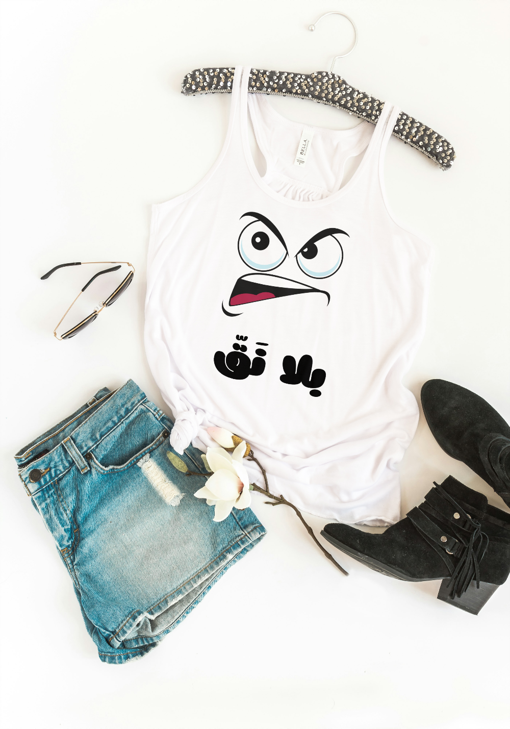 White tank top with cartoon face design, denim shorts, black boots, and sunglasses on a white background